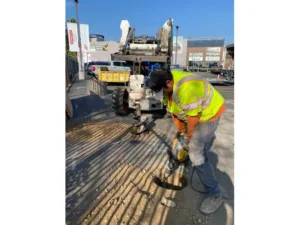 crew using an electric chipper saw inside hole
